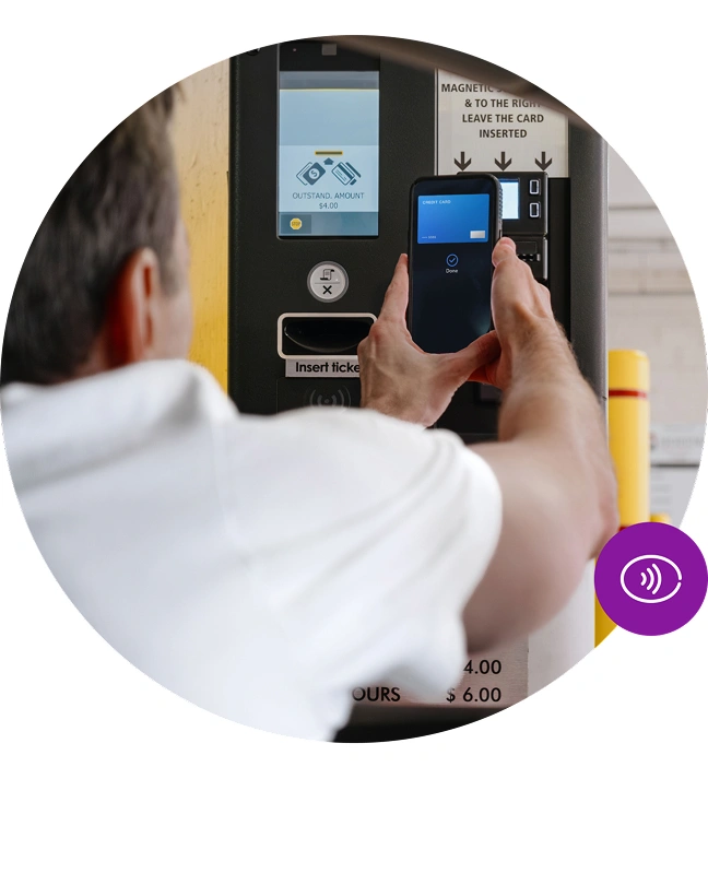 Zákazník platí mobilom pri automate na parkovací lístok.