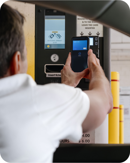 Vodič platí parkovné pomocou mobilného telefónu pri parkovacom automate.