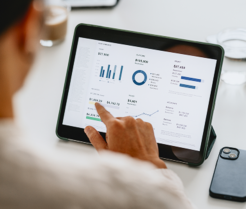 Osoba analyzuje finančné dáta a grafy na tablete.